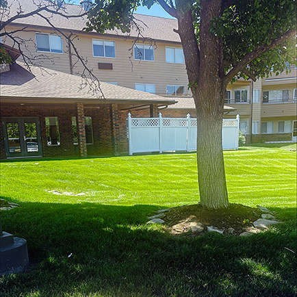 The vibrant green landscaped grounds and exterior of Buckingham Senior Living.