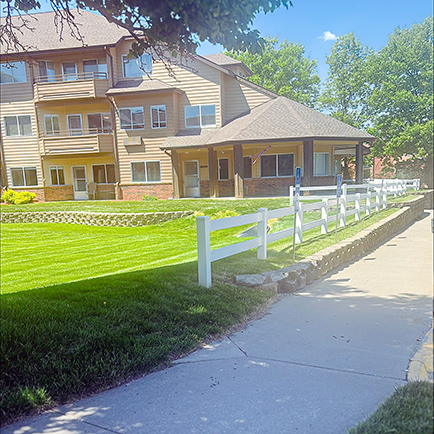The vibrant green landscaped grounds and exterior of Buckingham Senior Living.