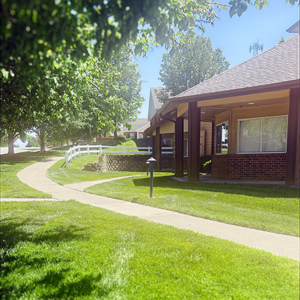The vibrant green landscaped grounds and exterior of Buckingham Senior Living.